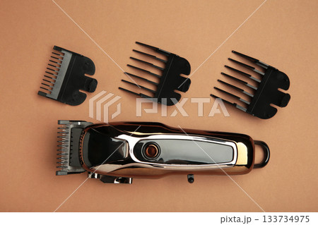 Hair clipper on brown background. Modern hair clipper. Hair clipper on brown background. Modern hair clipper. 133734975