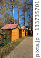 Row of Wooden Christmas Market Stalls in Forest Under Clear Blue Sky 133735701