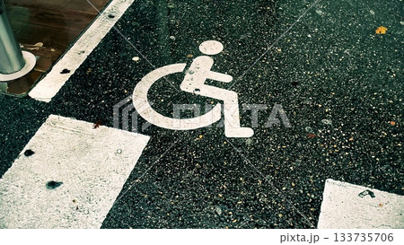 Wheelchair symbol on asphalt road marking. Concepts of accessibility, mobility, public infrastructure, and transportation 133735706