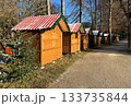 Row of Wooden Christmas Market Stalls With Red Striped Roofs in Bad Aibling Along Tree-Lined Path 133735844