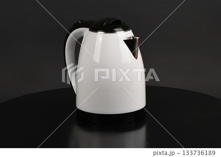 Modern White and Black Electric Kettle on Dark Surface 133736189