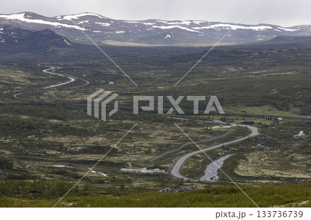 Road E6 winds through the scenic Dovrefjell Sunndalsfjella National Park in Norway's beautiful landscape 133736739