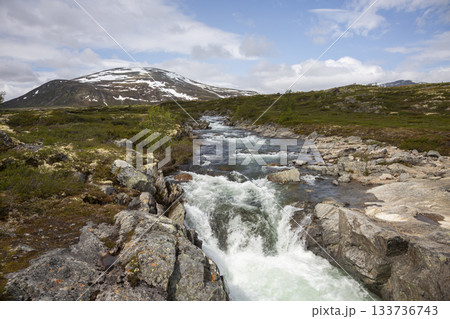 Majestic waterfall flowing through Dovrefjell Sunndalsfjella National Park under a clear sky in Norway Majestic waterfall flowing through Dovrefjell Sunndalsfjella National Park under a clear sky in Norway 133736743