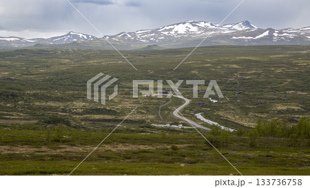 Winding E6 road through scenic Dovrefjell-Sunndalsfjella National Park in Norway surrounded by mountains and lush greenery Winding E6 road through scenic Dovrefjell-Sunndalsfjella National Park in Norway surrounded by mountains and lush greenery 133736758