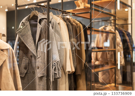 winter clothes coats on hangers in a store on a showcase in a shopping center	 133736909