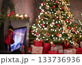 christmas tree in the mall for christmas with garland and decorations on blurred bokeh background with a fireplace 133736936