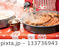 vendor fries meat and sausage on the grill in the city center at the Christmas market in Gdansk Poland 133736943