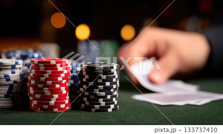 Colorful Poker Chips and Playing Cards on Casino Table During High-Stakes Game 133737410