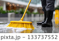 Yellow Cleaning Mop and Worker Boots on Wet Shiny Floor 133737552