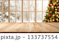 Wooden Table Surface with Blurred Christmas Tree and Snowy Window Background 133737554