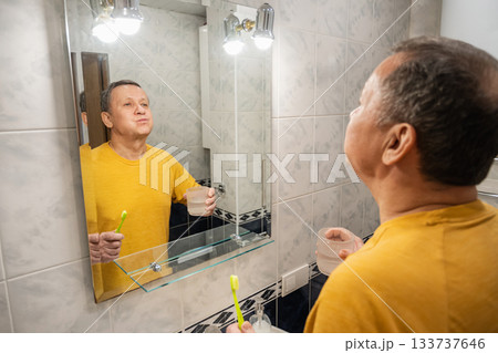 Rinsing mouth with water after brushing teeth , caucasian adult male completing morning oral hygiene at home sink. Man Brushing Teeth 133737646