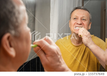 Brushing teeth with foam in mirror, caucasian adult male performing morning oral hygiene routine at bathroom sink. Man Brushing Teeth Brushing teeth with foam in mirror, caucasian adult male performing morning oral hygiene routine at bathroom sink. Man Brushing Teeth 133737649