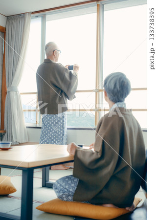 スマホで景色を撮る高齢夫婦の旅館シーン スマホで景色を撮る高齢夫婦の旅館シーン 133738395