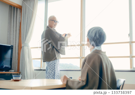 スマホで景色を撮る高齢夫婦の旅館シーン 133738397