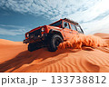 Offroad jeep climbing orange sand dunes and kicking up dust under a bright blue sky 133738812