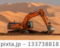 Orange excavator pushing sand at the foot of massive desert dunes under soft overcast light 133738818