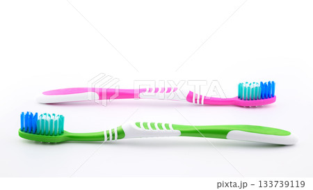 green and pink toothbrushes on white background close-up, side view green and pink toothbrushes on white background close-up, side view 133739119