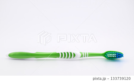 green toothbrush on white background close-up, side view 133739120