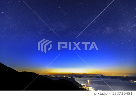 早春の瀬戸内の薄明の星景　港町の夜景と多島美の空の天の川アーチ 133739481