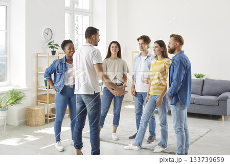 Group of diverse friends standing in the living room at home and having a discussion 133739659