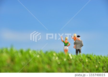 青空の下で手を振る家族イメージ 133740015