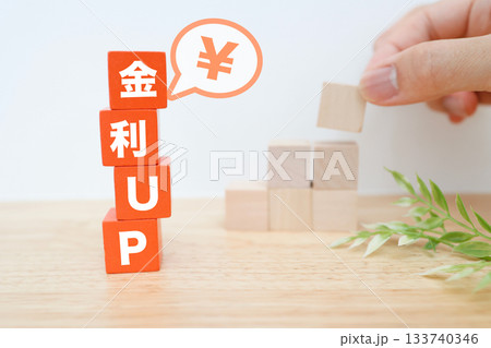 金利上昇と円の価値を示す積み木と吹き出しの金融イメージ。 金利上昇と円の価値を示す積み木と吹き出しの金融イメージ。 133740346