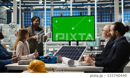 Solar panels plant manager uses isolated screen monitor to present manufacturing strategies to investors. Photovoltaics factory executive uses mockup display to show data to shareholders, camera A 133740440