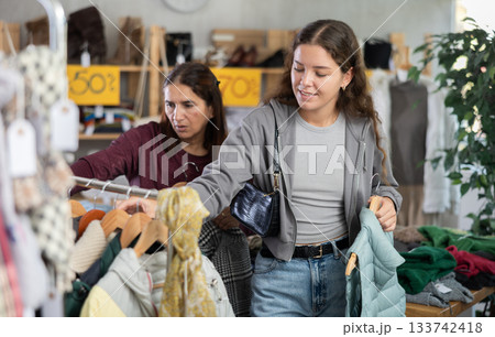 During November sales, young woman choose and buy something autumn outwear 133742418