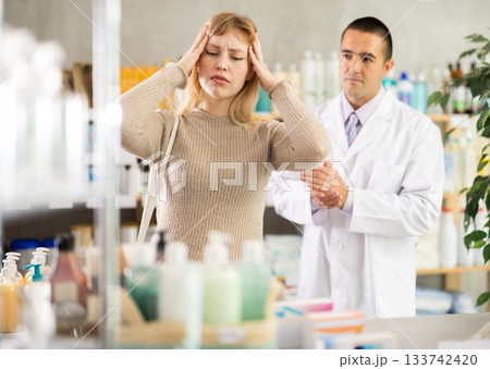 Girl pharmacy client suffers from headache, pharmacist want to help 133742420