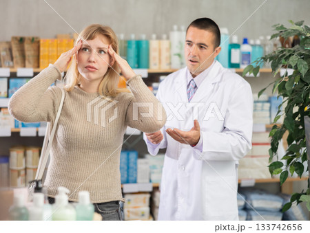 Woman with headache on the background of a pharmacist 133742656