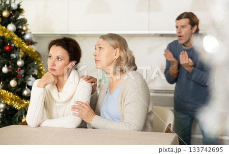 Senior woman sits near daughter and comforts during quarrel with husband on Christmas Eve 133742695