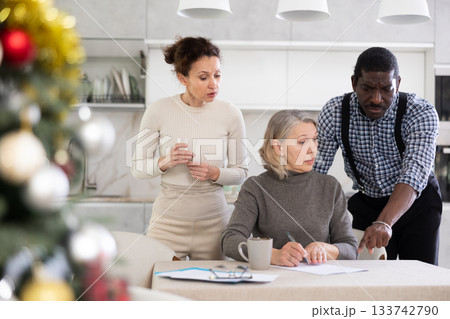 Mature woman relatives tell her who to include in her will during Christmas celebrations 133742790