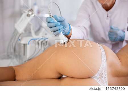 Young woman undergoing high frequency ultrasound procedure on buttocks 133742800