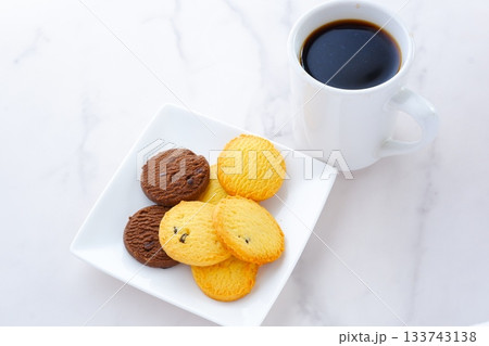白いお皿に盛ったおいしそうなクッキーと、淹れたての香ばしいコーヒーで、コーヒーブレイクの幸せな時間 白いお皿に盛ったおいしそうなクッキーと、淹れたての香ばしいコーヒーで、コーヒーブレイクの幸せな時間 133743138