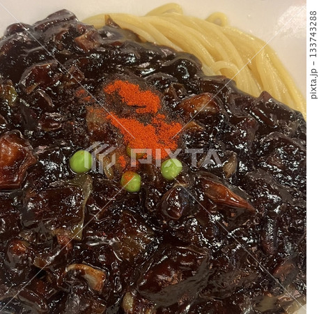 Classic jajangmyeon with thick noodles in a rich black bean sauce, garnished with sliced cucumber and sesame seeds. A beloved Korean-Chinese comfort dish, full of savory depth and flavor. 133743288