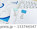 クリップで挟んだ書類とグラフとパソコン 133744347