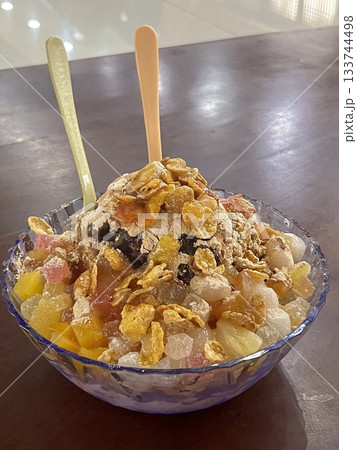 Refreshing bingsu, a Korean shaved ice dessert topped with sweet ingredients like red beans, fruits, and condensed milk. A perfect treat to cool down on hot days. Refreshing bingsu, a Korean shaved ice dessert topped with sweet ingredients like red beans, fruits, and condensed milk. A perfect treat to cool down on hot days. 133744498