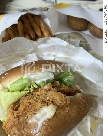 A mouthwatering burger with a juicy patty, fresh lettuce, tomato, and melted cheese, all nestled in a soft bun. Perfect for food photography, showcasing the indulgence of classic comfort food. 133744569