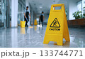 Caution wet floor sign with cleaners team wiping dust and mopping office service. 133744771