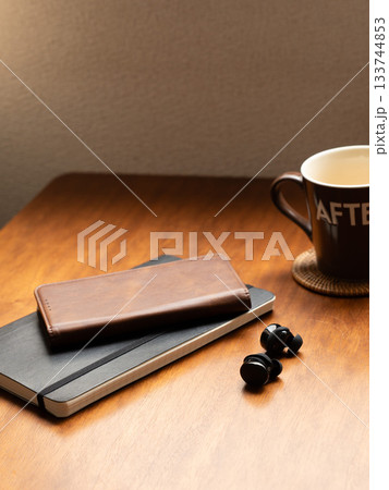 テーブルの上の手帳とイヤホンとマグカップ テーブルの上の手帳とイヤホンとマグカップ 133744853