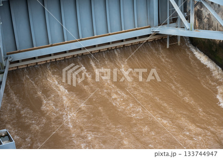 Spillway of Chiang Rai dam open for release water. Spillway, passage for surplus water over or around a dam when the reservoir itself is full. 133744947
