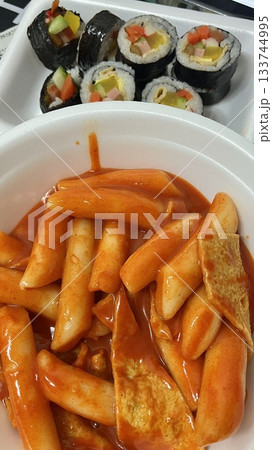 Spicy Korean tteokbokki with chewy rice cakes in a vibrant red sauce, topped with sesame seeds and green onions. A popular street food known for its addictive flavor and satisfying texture. 133744995