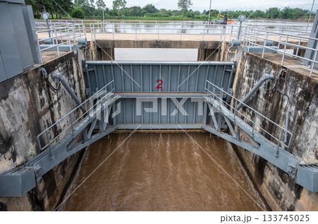 Spillway of Chiang Rai dam open for release water. Spillway, passage for surplus water over or around a dam when the reservoir itself is full. 133745025