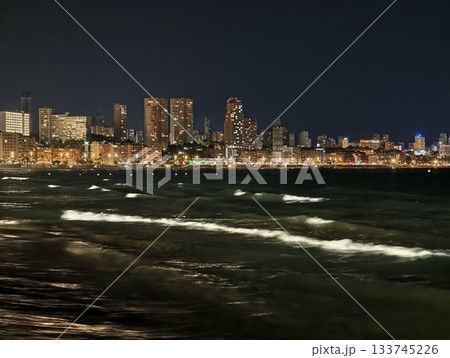 night reflections on urban waters, city lights reflect on restless water surfaces at night 133745226