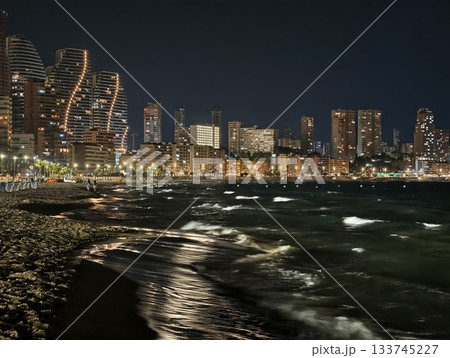 curved skyline by moonlit shore with shimmering water urban architecture and quiet coastal 133745227