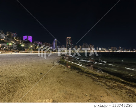 illuminated coastal promenade at night, nighttime bay with glowing promenade and distant skyscrapers illuminated coastal promenade at night, nighttime bay with glowing promenade and distant skyscrapers 133745250