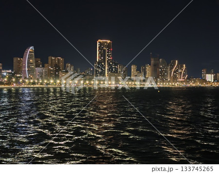 wide panoramic view capturing bustling city skyline with sparkling water reflections and illuminated wide panoramic view capturing bustling city skyline with sparkling water reflections and illuminated 133745265