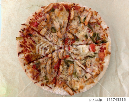freshly baked rustic pizza on parchment paper, delicious warm rustic pizza slices served 133745316