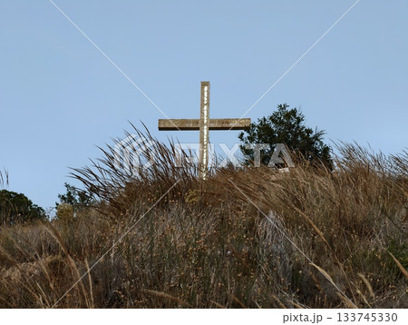 guiding cross on grassy ridge, bright cross atop grassy ridge guiding explorers and pilgrims 133745330