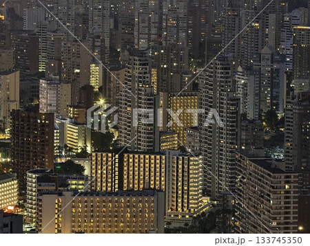 night city with illuminated buildings, urban skyline illuminated with glowing windows and vibrant 133745350
